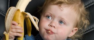 маленький мальчик ест банан