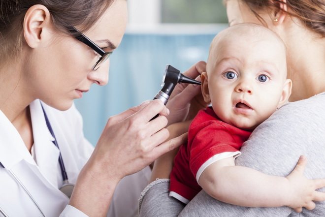 врач проверяет ухо ребенка